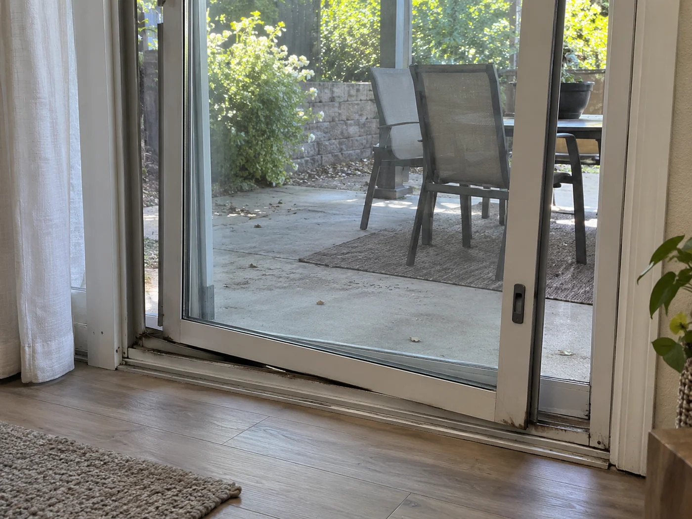 Sliding door off its worn track before professional repair in Kendall