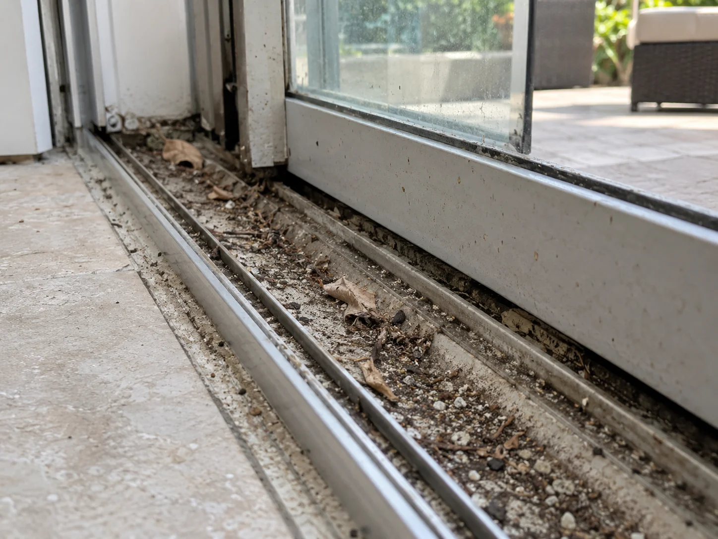 Debris-clogged sliding door track making the door hard to open