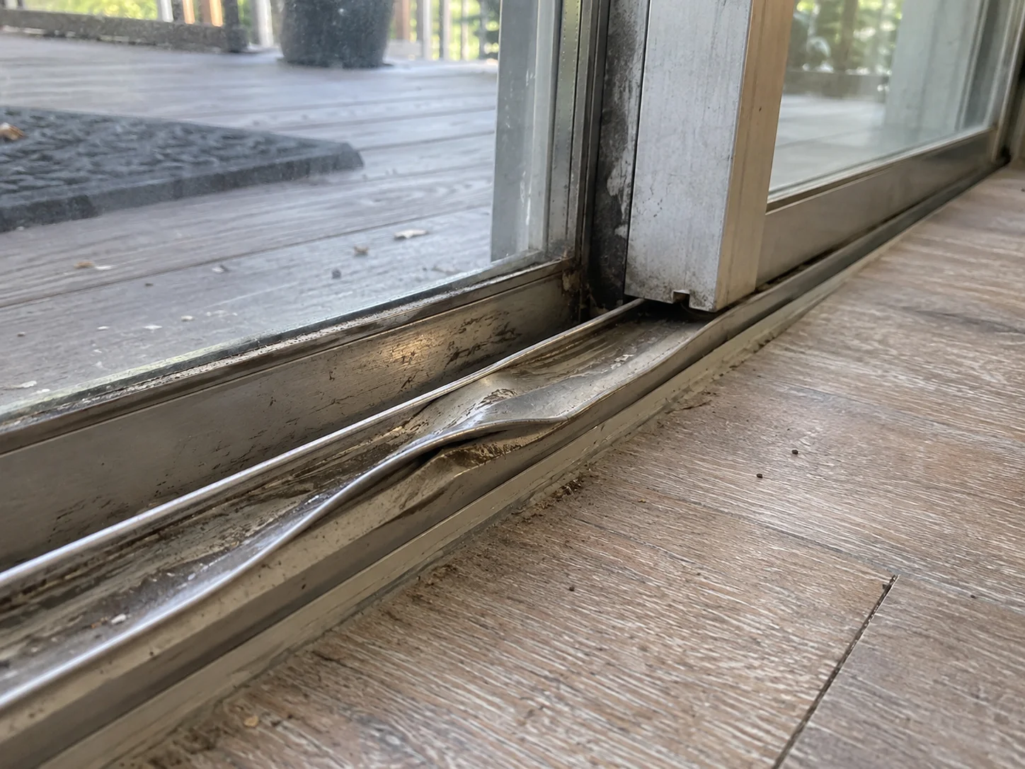 Before: badly bent and crushed sliding door track from storm damage