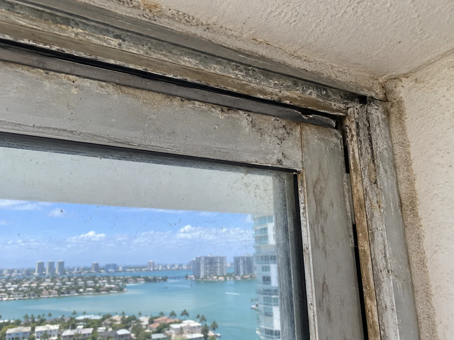 Before: heavily corroded sliding door frame with dirty deteriorated glass seal