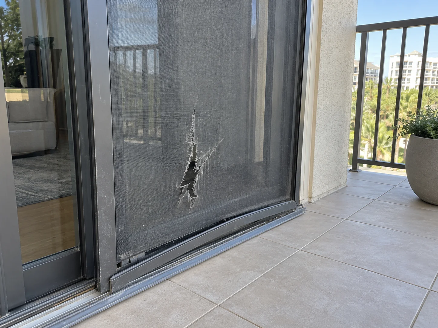 Before: torn and punctured sliding screen door on balcony